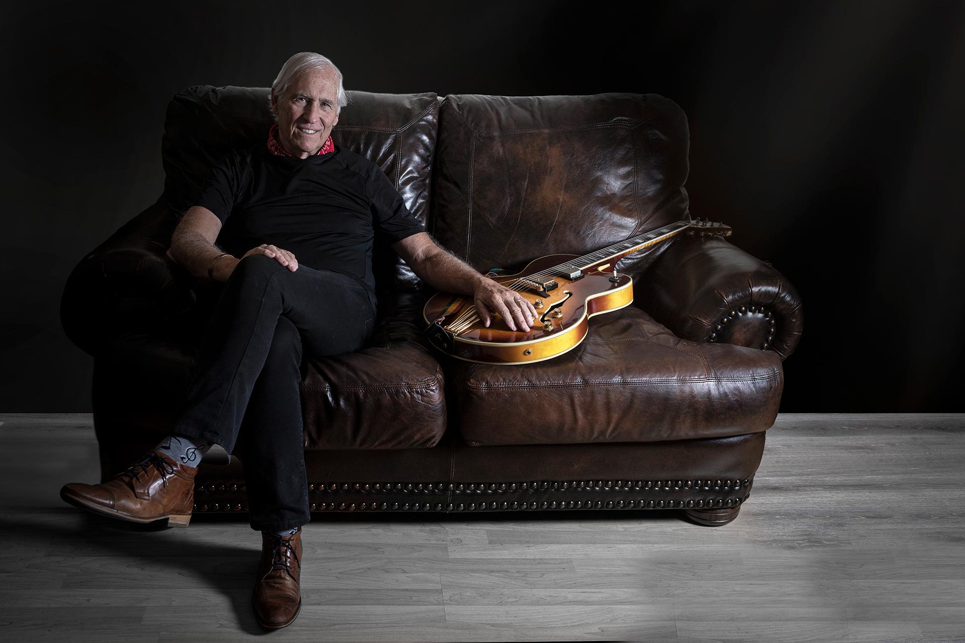 Nick Binkley sitting on the couch with his guitar